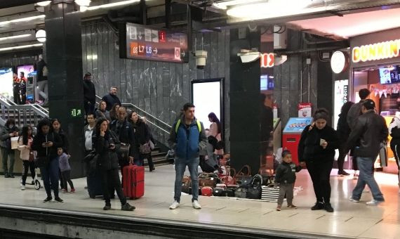 Un mantero en el andén de plaza Catalunya, con vigilantes de seguridad al fondo / P. A.