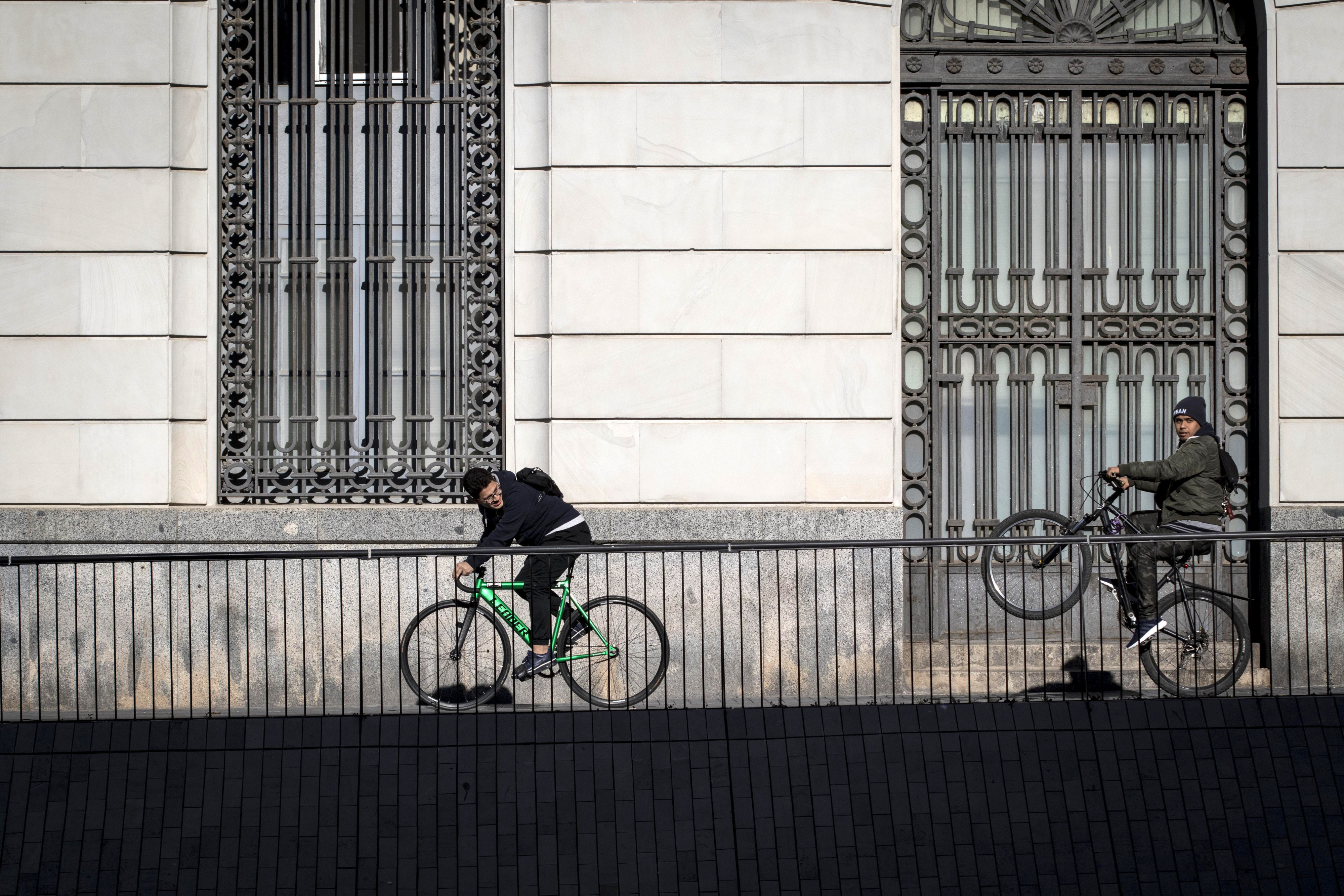 Bicicletas en las aceras de BCN, en una de ellas el ciclista levanta la rueda delantera / HUGO FERNÁNDEZ