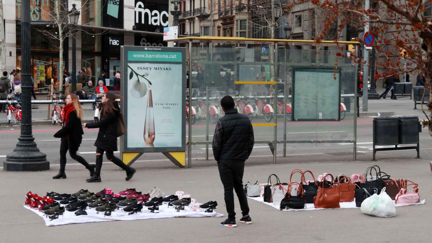 Un vendedor ambulante en Plaza Catalunya / HUGO FERNÁNDEZ