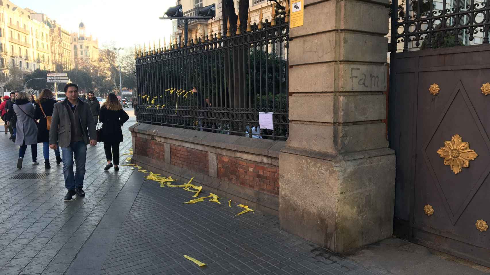 Una miembro del personal de limpieza del Palau Robert retirando los lazos amarillos de las vallas / METRÓPOLI ABIERTA