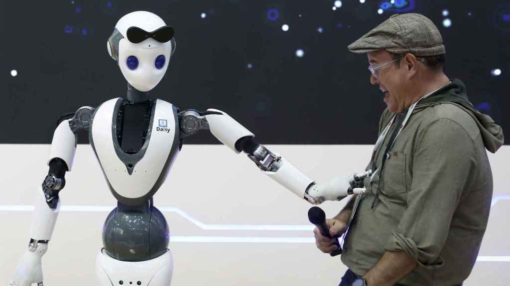 Un congresista del MWC con un robot en Fira Barcelona / EFE