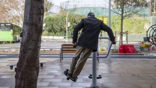 Una persona mayor haciendo gimnasia en plena calle / HUGO FERNÁNDEZ