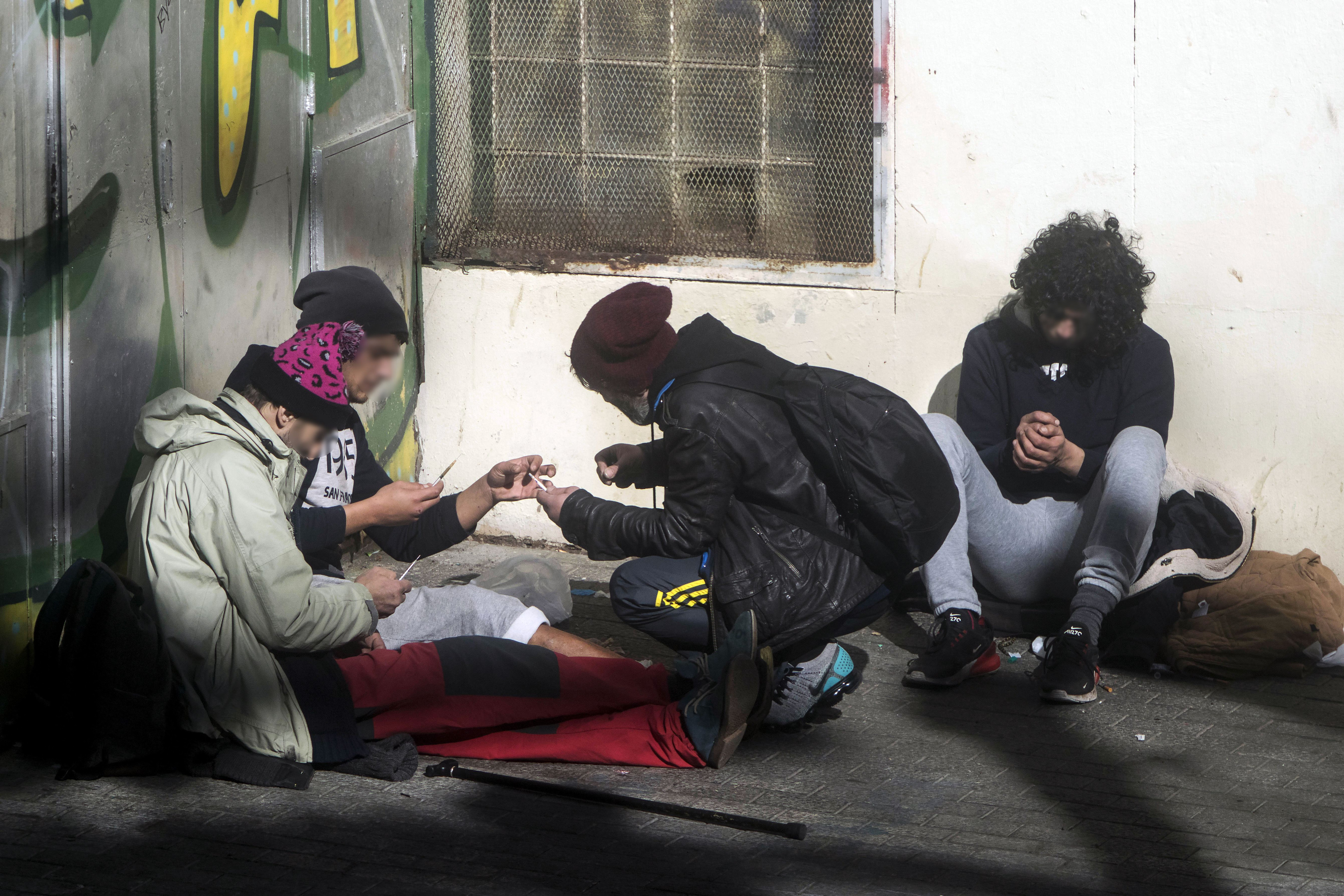 Un grupo de toxicómanos pinchándose en la calle a plena luz del día en el Raval / HUGO FERNÁNDEZ