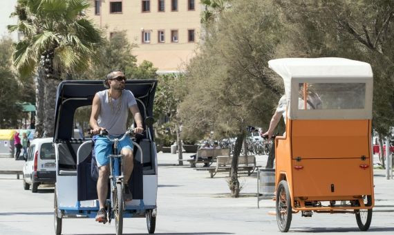 Bicitaxis circulando por el paseo de la Barceloneta / HUGO FERNÁNDEZ