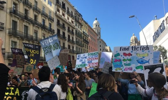 Unos jóvenes con un cartel que critica el exceso de plástico en el mar / PM