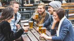 Grupo de amigos tomando algo y haciendo intercambio de idiomas / SHUTTERSTOCK