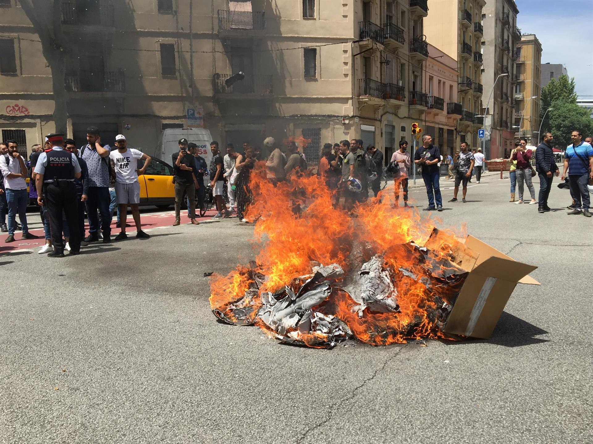 Mochilas, neumáticos y cajas ardiendo ante la sede de Glovo en Barcelona / EP