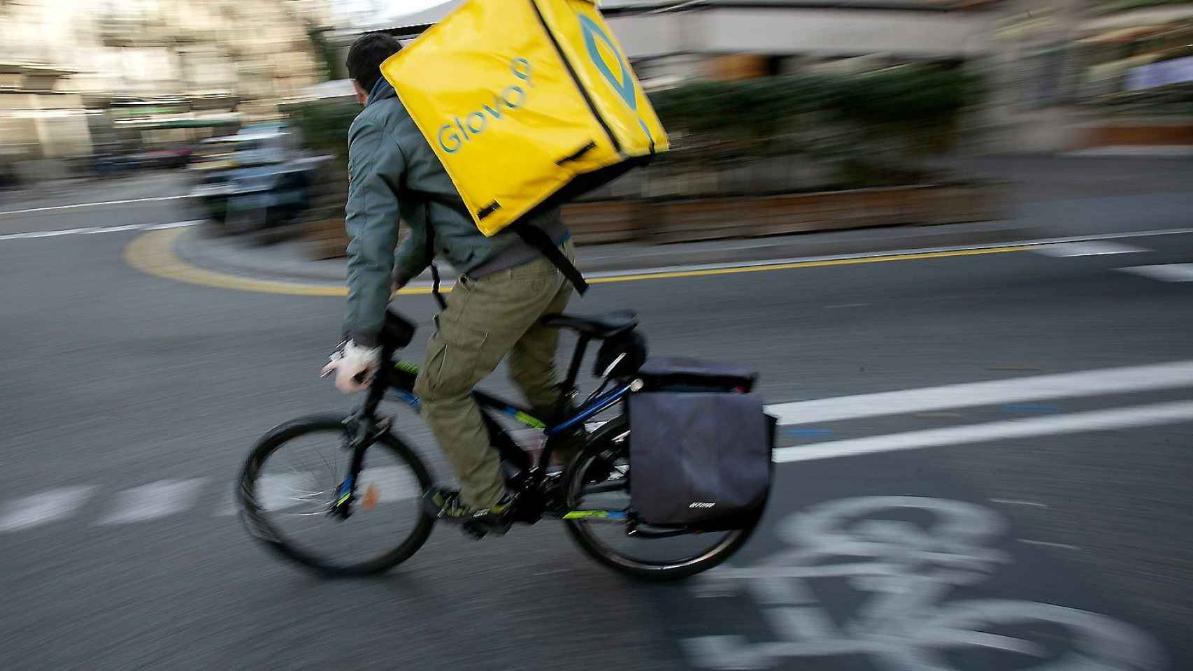 Un repartidor de la compañía Glovo pedaleando por una calle