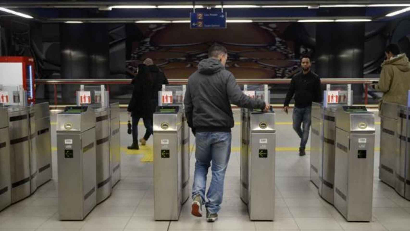 Un usuario pasando la tarjeta para acceder al suburbano de Barcelona