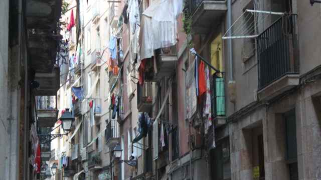 Calle estrecha llena de ropa colgada de los balcones en el barrio del Raval de Barcelona