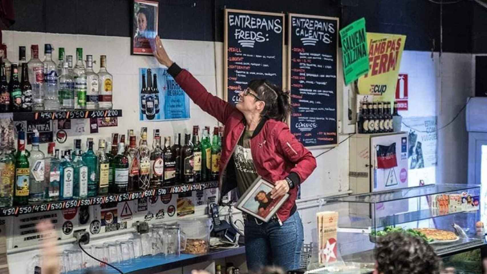 La etarra Marina Bernardó retira su foto en la pared del bar Resolís y cuelga la de Dolores López Resino, en Barcelona