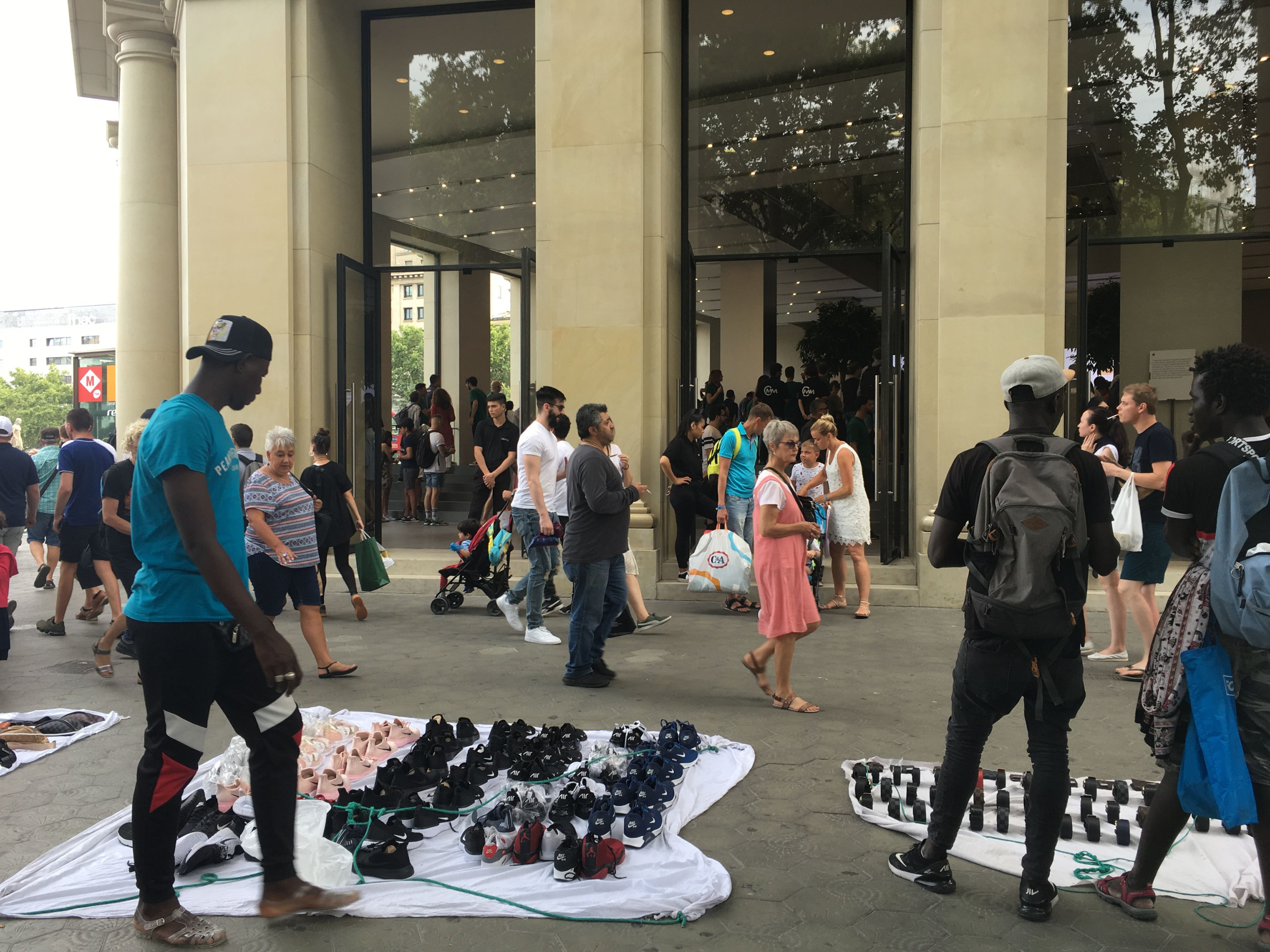 Manteros en el exterior de la tienda de Apple de plaza Catalunya / P. B.