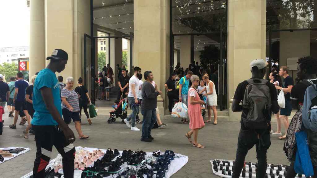 Manteros en el exterior de la tienda de Apple de plaza Catalunya / P. B.