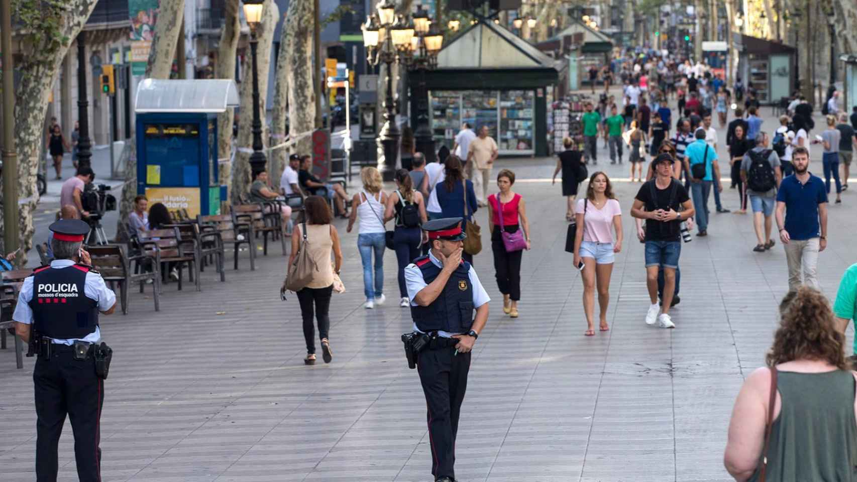 Varias personas paseando por la Rambla junto a dos miembros del cuerpo policial de la ciudad / CG