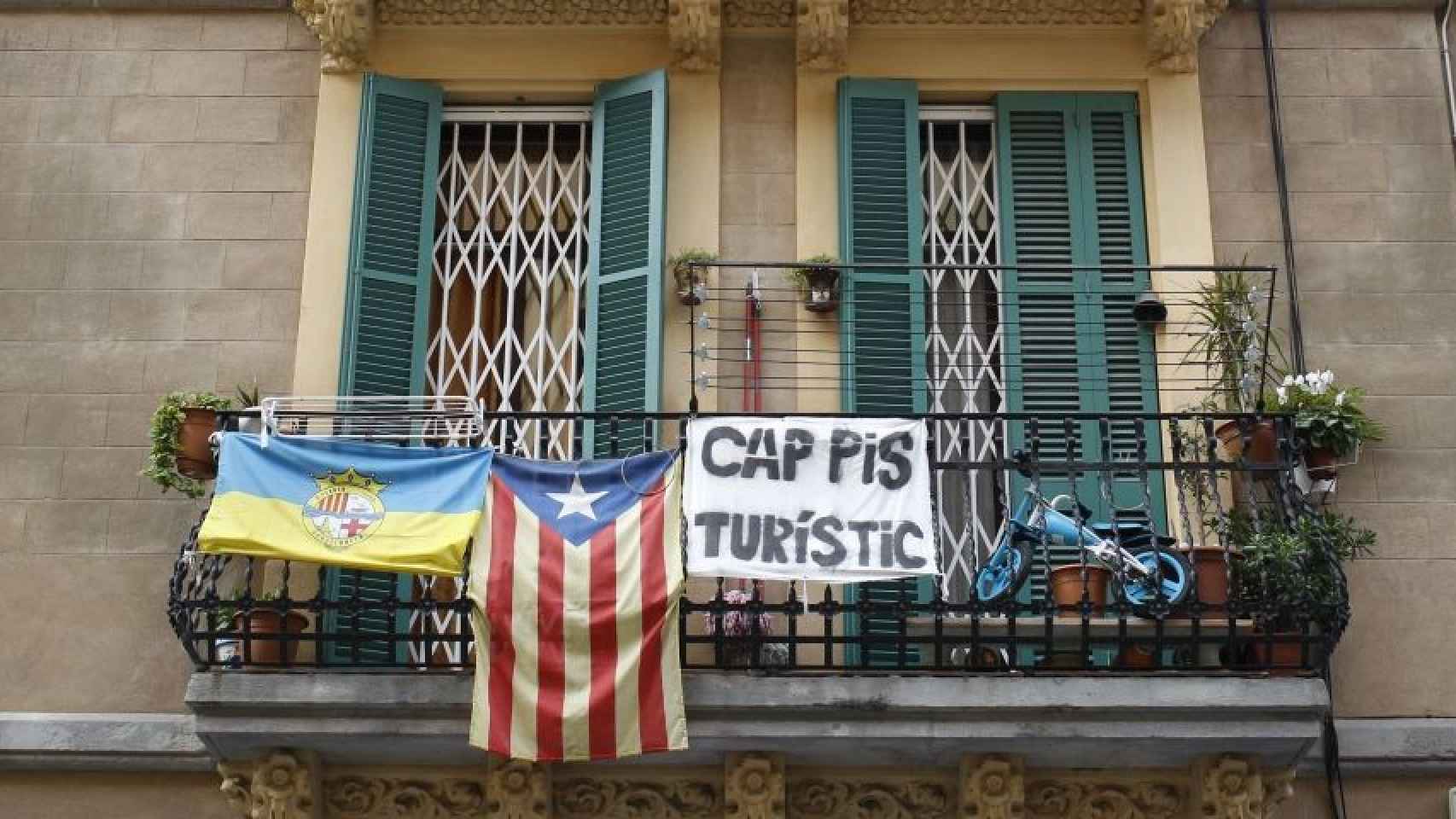 Cartel contra los pisos turísticos en un balcón de una vivienda / HUGO FERNÁNDEZ