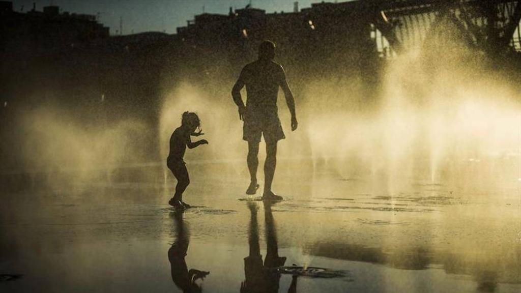 Dos personas se refrescan por las altas temperaturas de la ola de calor en Barcelona