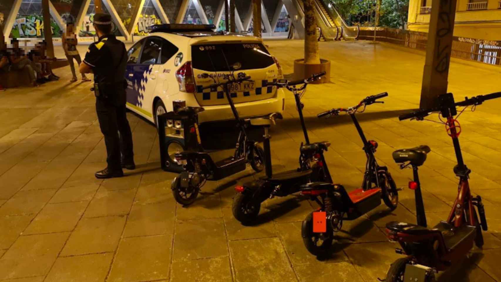 Un agente de la Guardia Urbana junto a varios patinetes eléctricos / @barcelona_GUB