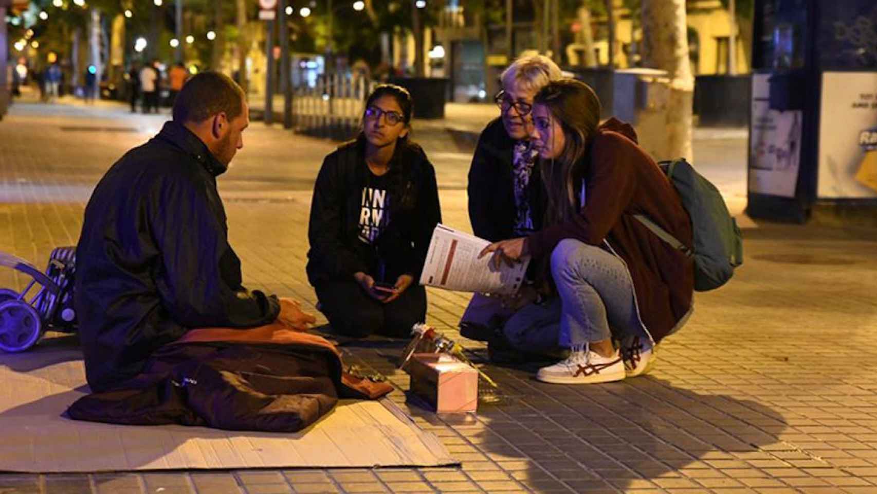 Un grupo de voluntarios de Arrels Fundació habla con una persona sintecho / ARRELS FUNDACIÓ