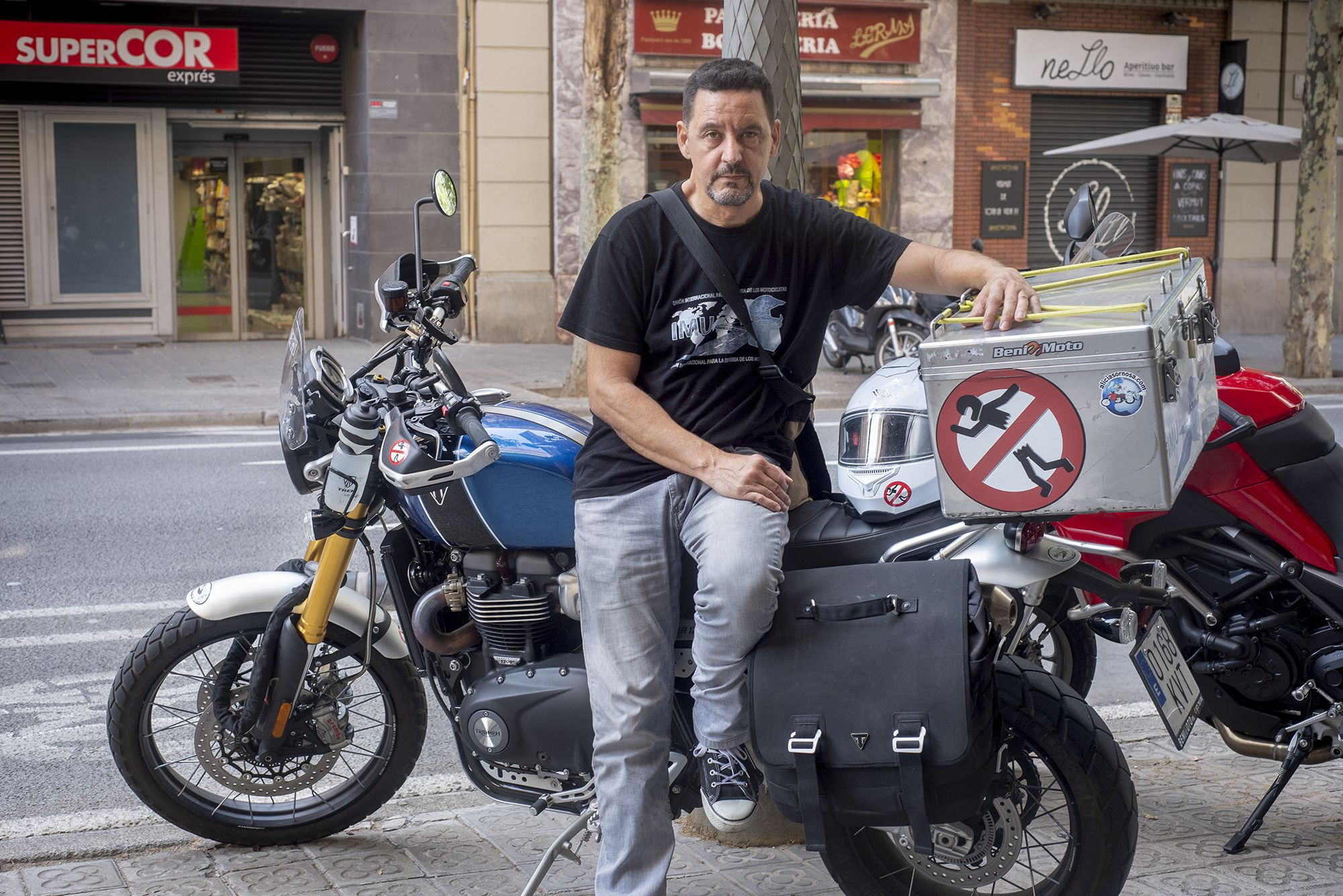 Juan Carlos Toribio posa junto a su moto, en la calle París de Barcelona / LENA PRIETO