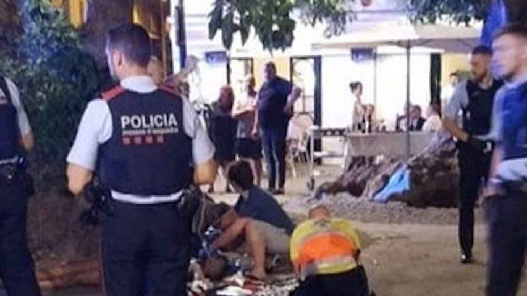 Agentes de los Mossos d'Esquadra y personal del SEM, atendiendo a una persona en una imagen de archivo / BCN HELPERS