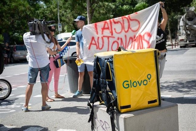 Un trabajador de Glovo manifestándose con un cartel de falsos autónomos / EP
