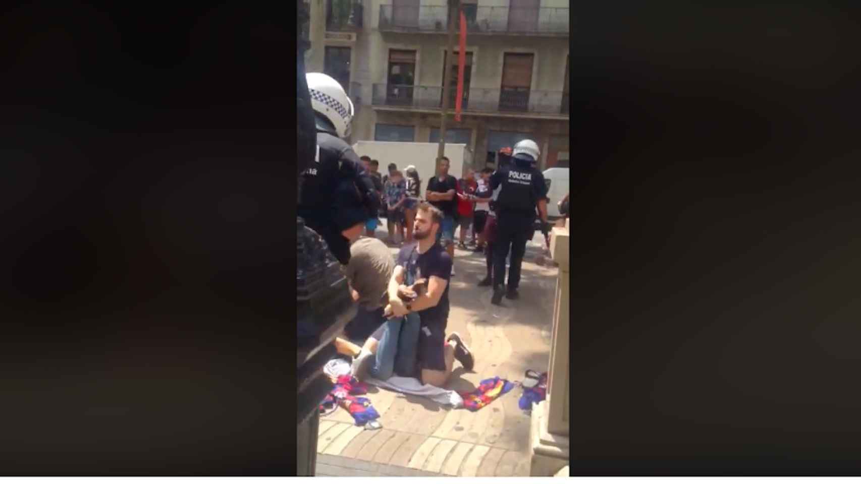 Agentes de la Guardia Urbana en La Rambla reduciendo a un mantero