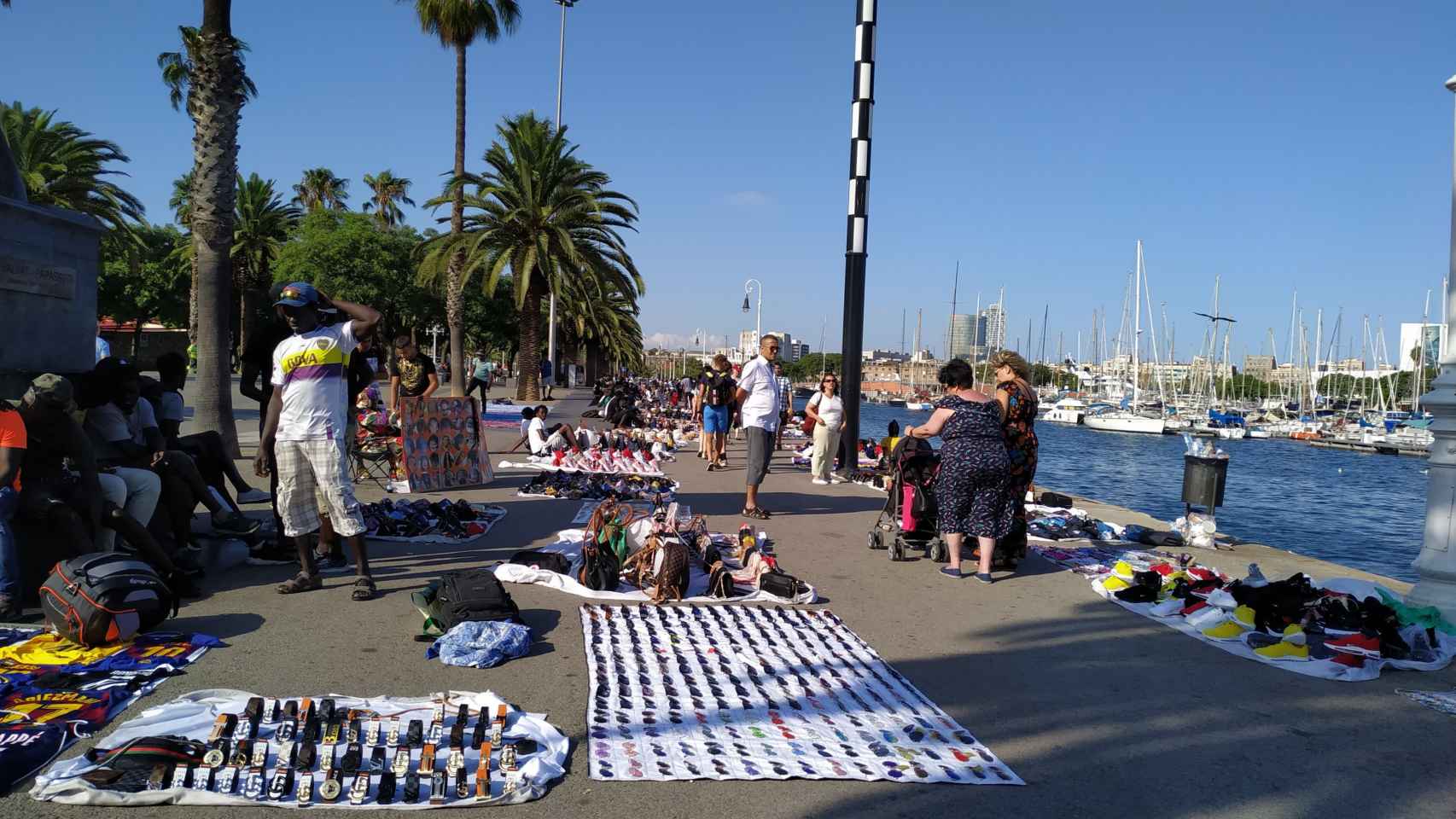 Manteros vendiendo en el paseo cerca del Port Vell de Barcelona / P. B.