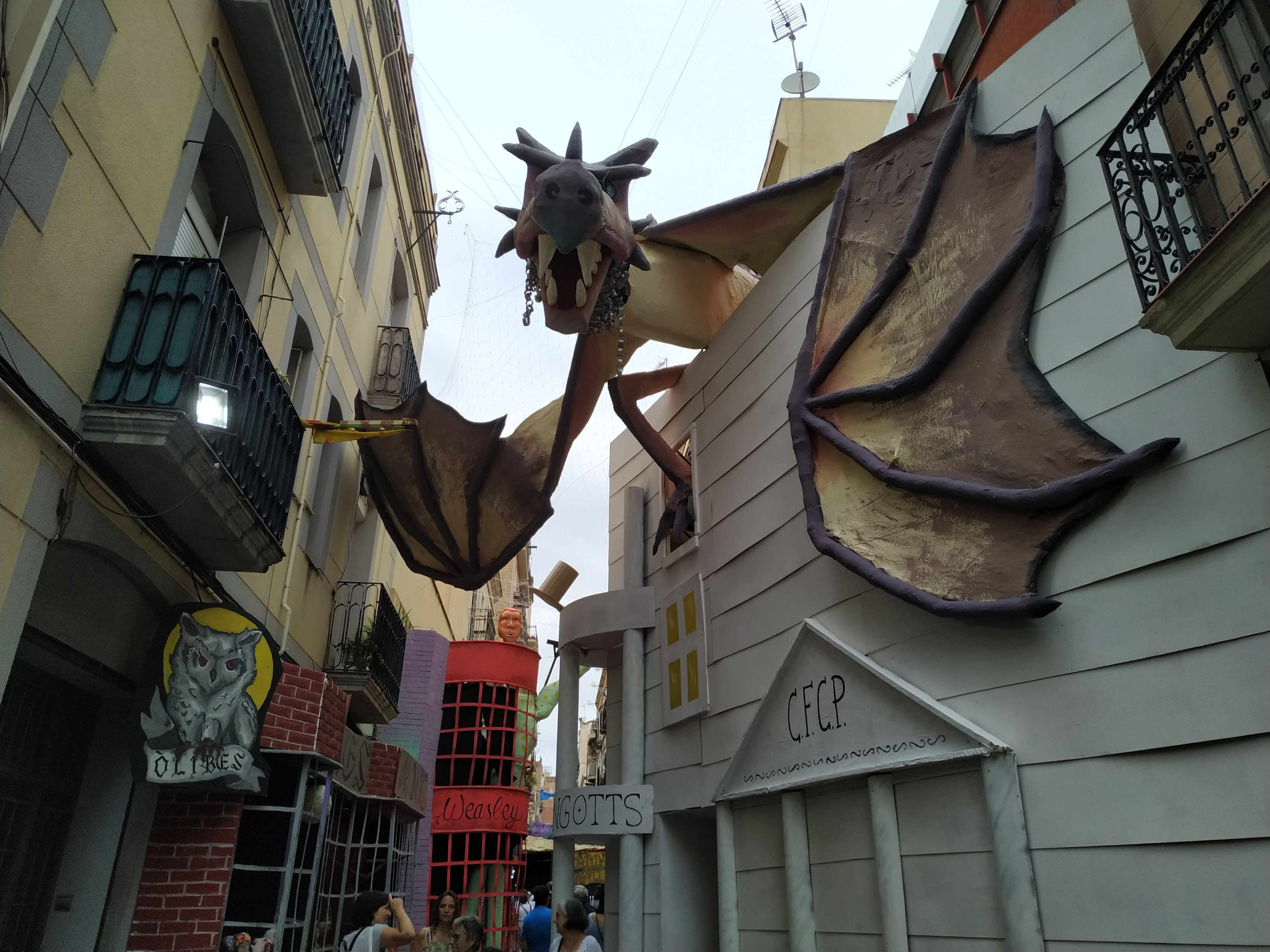 Un dragón en la calle Progrés con el universo de Harry Potter de fondo / P. B.