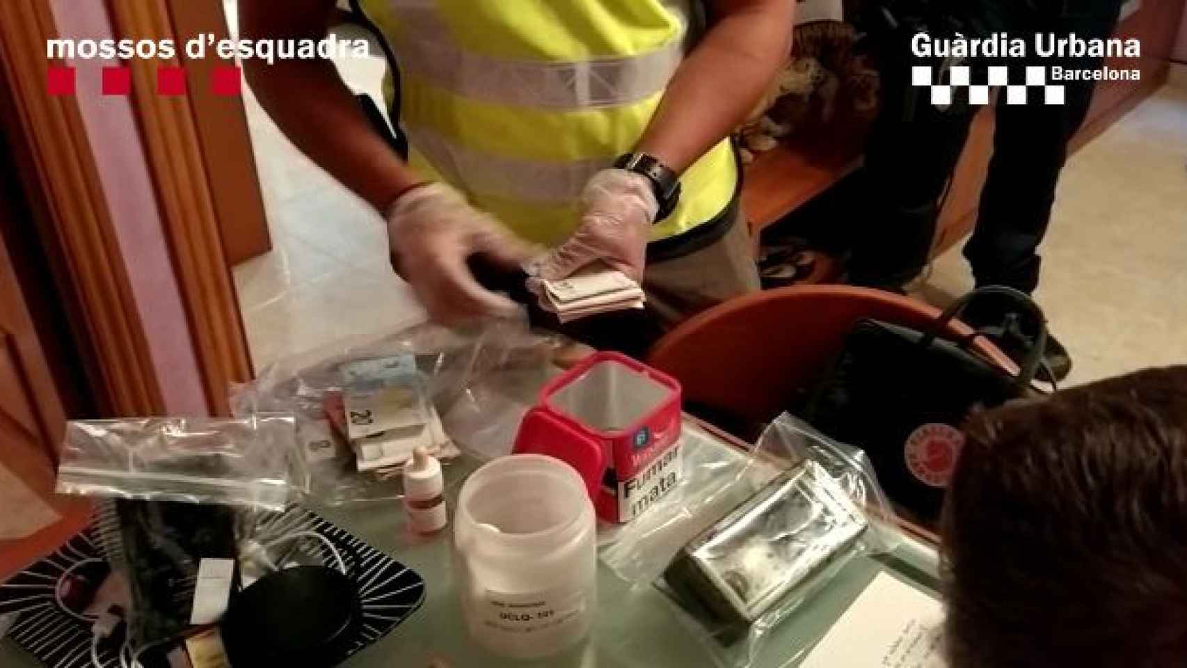 Un agente de la policía contando el dinero encontrado en la vivienda de Nou Barris / Mossos