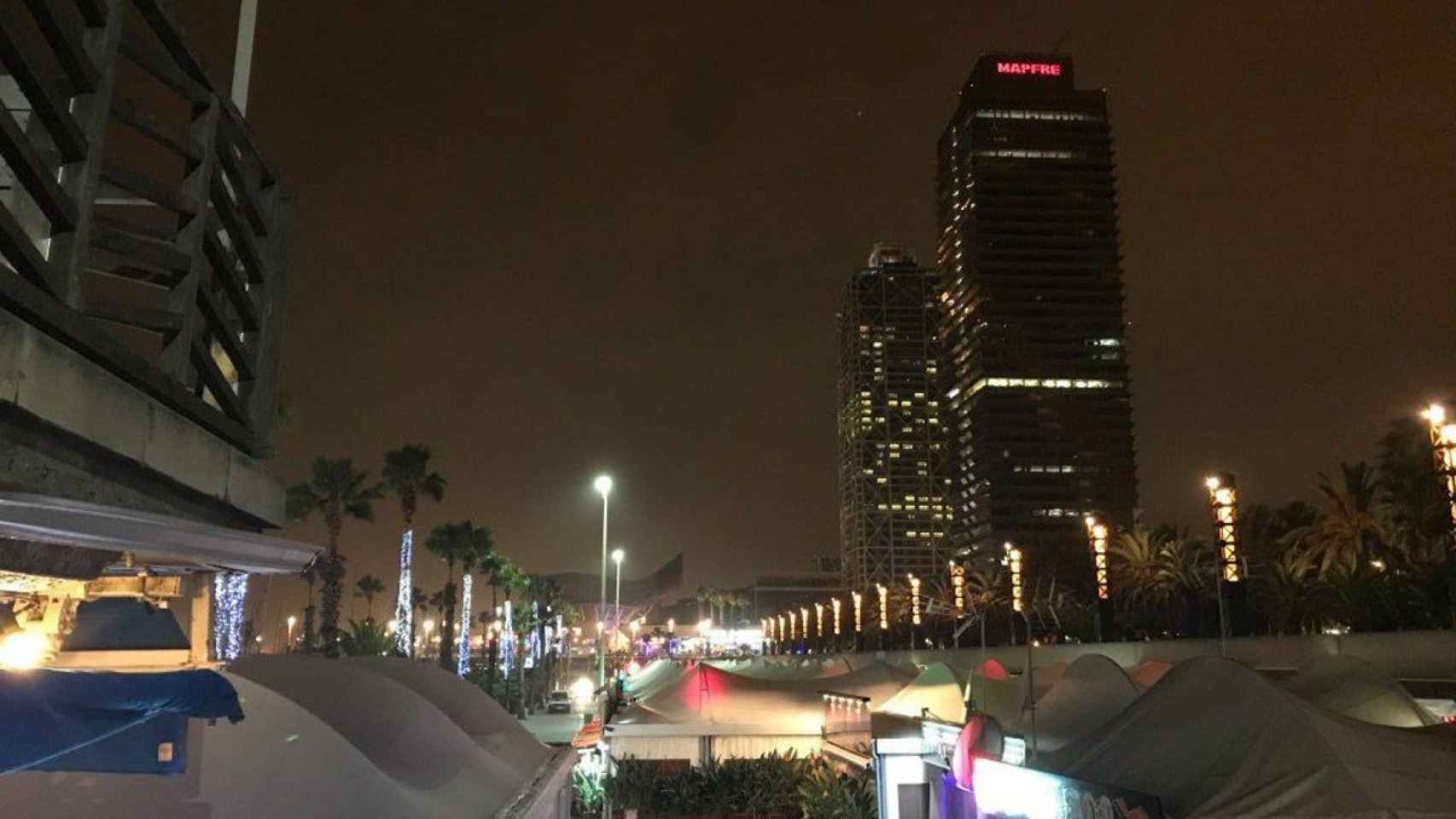 Bares del Port Olímpic de noche con las torres Mapfre de fondo