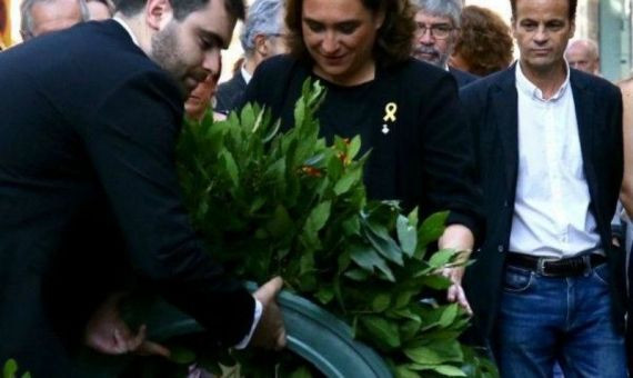 Colau realizando la ofrenda floral a Casanova con un lazo amarillo