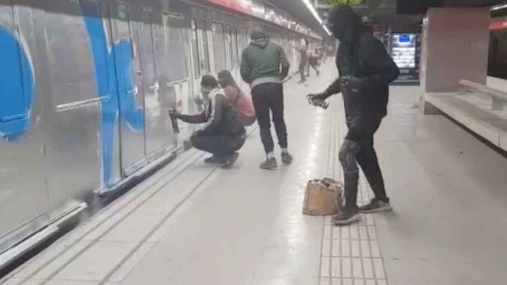 Un grupo de grafiteros pintan un metro en la Sagrera