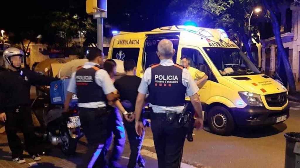 Los Mossos se llevan al hombre esposado tras reducirle en la pizzería / CG