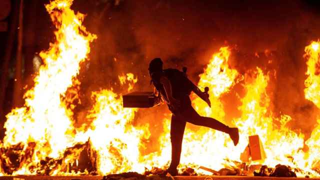 Un manifestante durante la protesta en Barcelona, que arde en llamas / EFE-Enric Fontcuberta