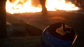 Un casco de eCooltra frente a una barricada / ROGER VILÀ