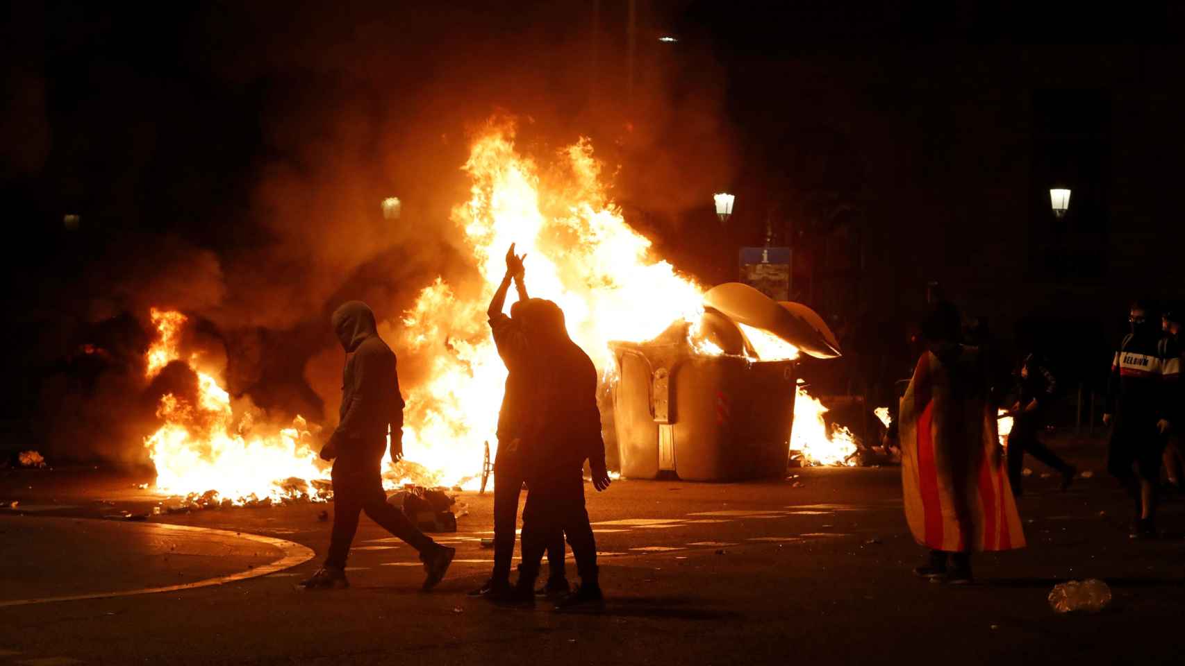 Los manifestantes radicales celebrando su victoria después de prender una hoguera enorme / EFE