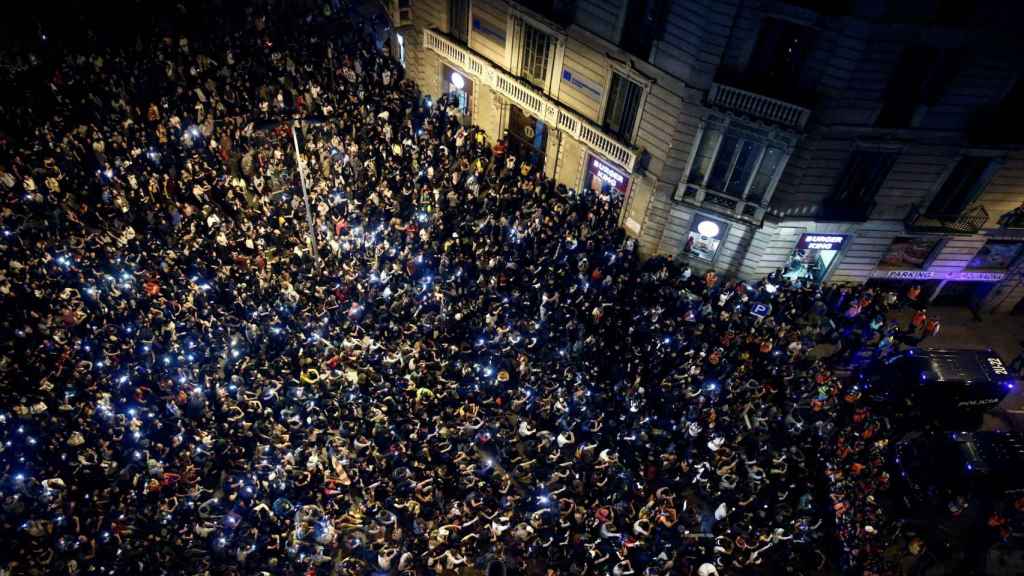 Centenares de personas permanecen sentados en la plaza de Urquinaona