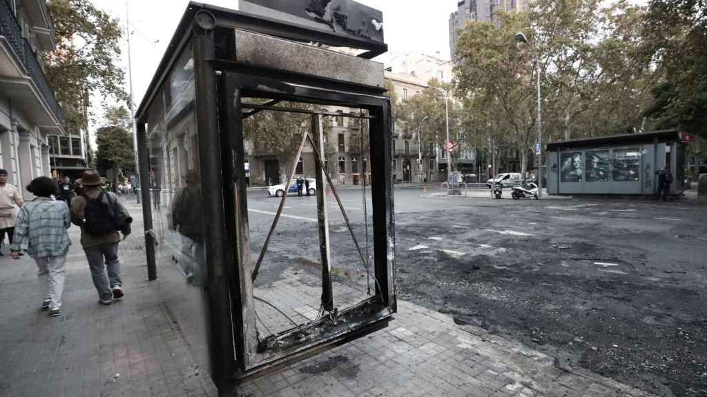 Aspecto que presenta este sábado las calles de Barcelona en la que han quemado una marquesina de bus tras los incidentes registrados anoche en los enfrentamientos después de la huelga