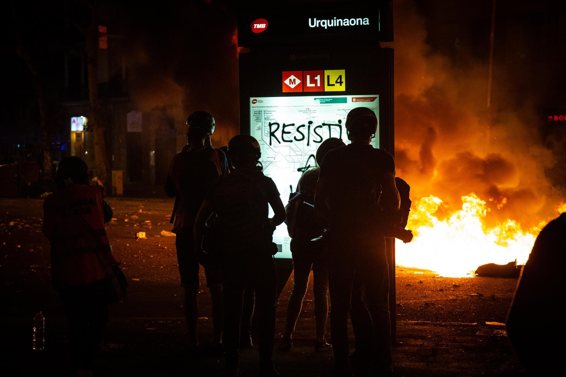 Varios policías junto a las llamas ocasionadas en el centro de Barcelona / EUROPA PRESS