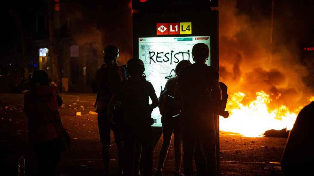 Varios policías junto a las llamas ocasionadas en el centro de Barcelona / EUROPA PRESS