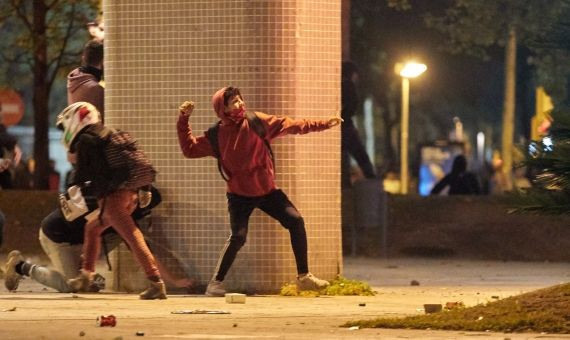 Un encapuchado lanza piedras, presuntamente contra la policía / EFE