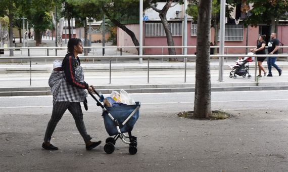 Una mujer con la compra paseando por la calle de Alfons el Magnànim en el Besòs / LENA PRIETO