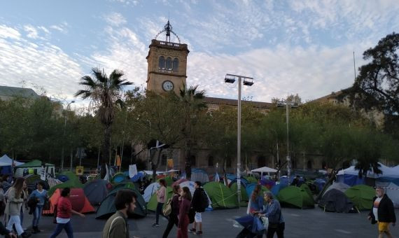 Turistas y ciudadanos pasando por la acampada en plaza Universitat / P.B.