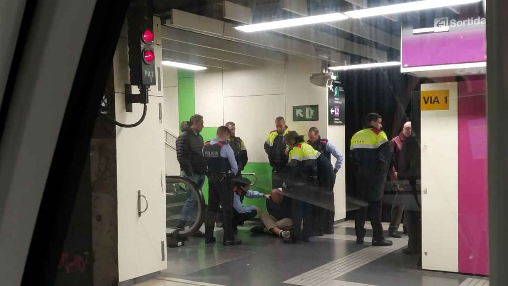 Varios agentes de la policía arrestando al presunto agresor en el metro.