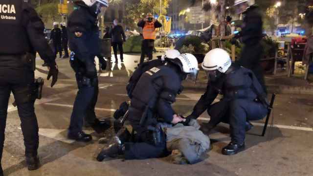 Agentes de la URPE de la Guardia Urbana detienen a un joven este miércoles.