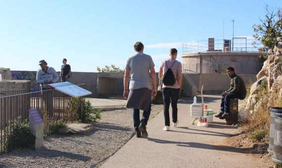 Un grupo de lateros ofrece refrescos y cerveza a los turistas que visitan los bunkers del Carmel / AR