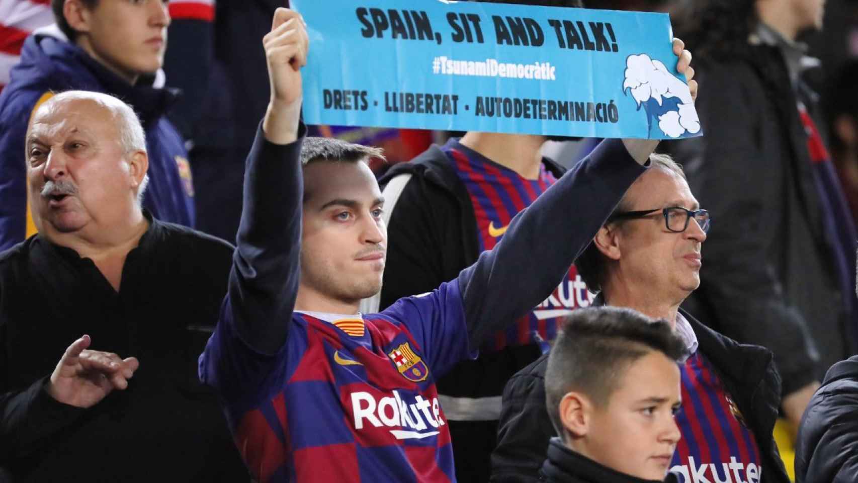 Un manifestante levantando un cartel de Tsunami Democràtic en un partido del Barça