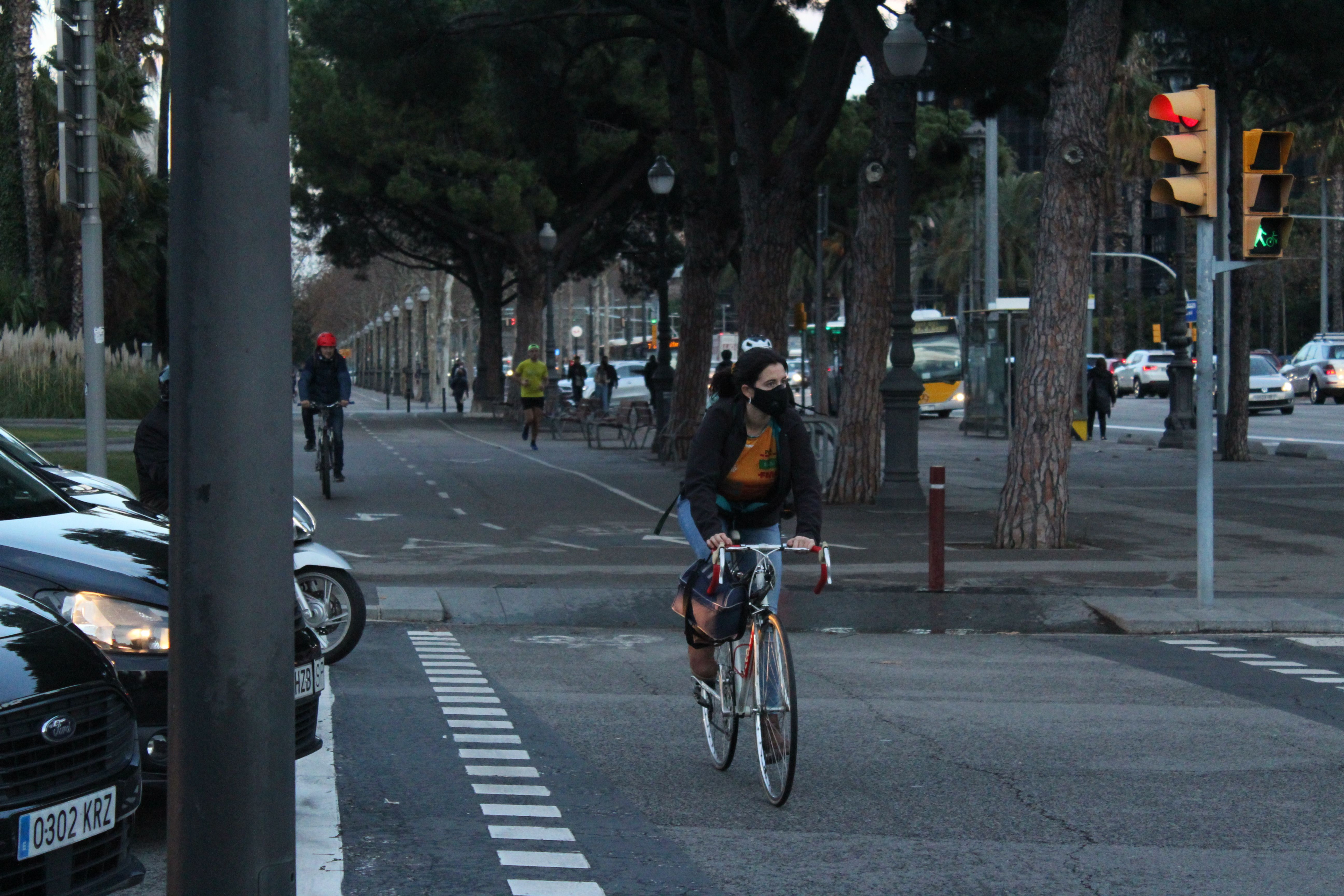 Una mujer con una mascarilla en la boca va en bicicleta por uno de los carriles habilitados en la Diagonal / AR