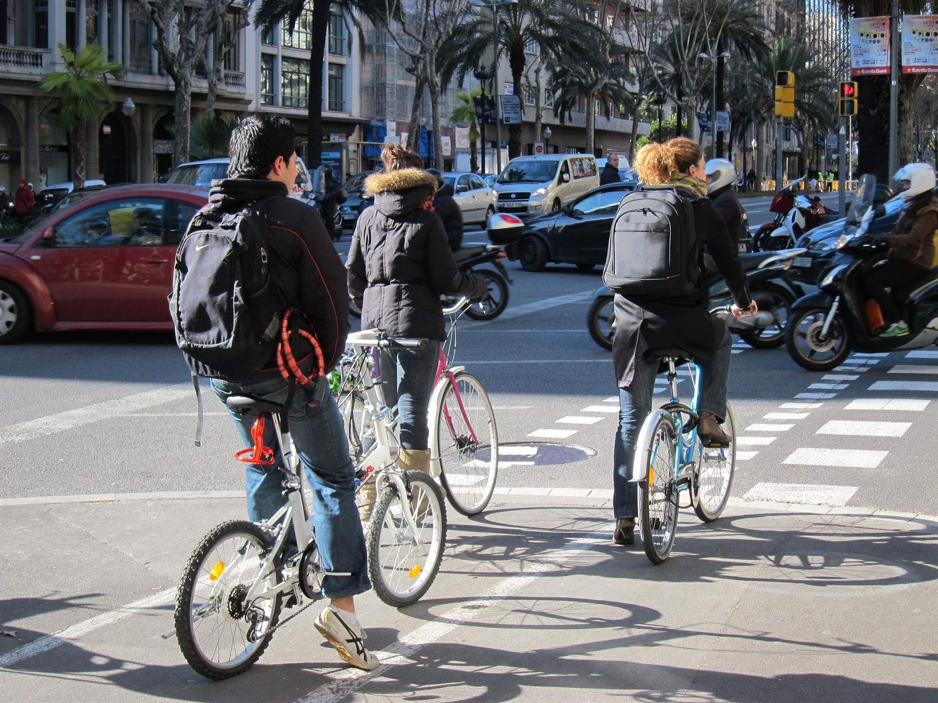 Tres ciclistas se desplazan por Barcelona en una jornada laboral anterior a la crisis del coronavirus.