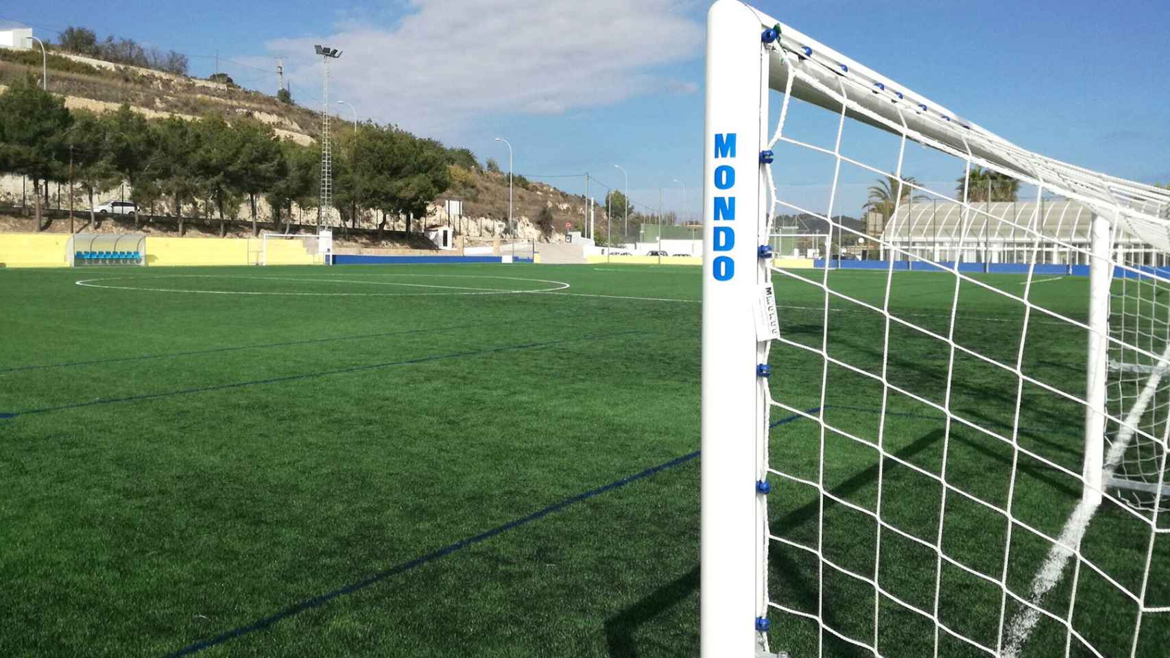 Campo de futbol con una portería y varios banquillos